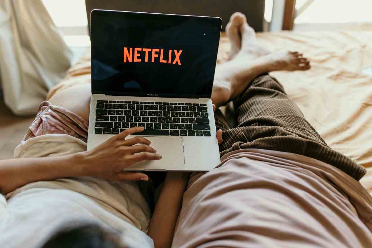 Persone sdraiate guardano Netflix sul pc portatile